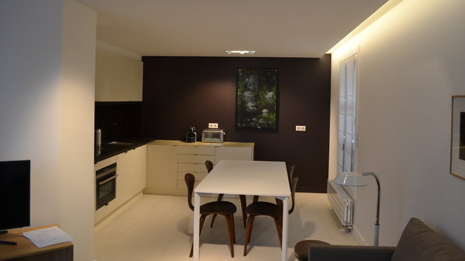 La cuisine est personnalisée par un mur de couleur marron qui a été habillé de PaperStone ®, un matériau issu du papier 100 % recyclé, aggloméré  avec des résines naturelles à base d’eau et d’huile d’anacarde (noix de cajou).