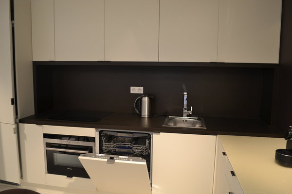 La cuisine aménagée avec des caissons basiques (Ikea) est personnalisée avec un plan de travail et une crédence en PaperStone®, un matériau recyclable, hydrofugé, imperméable et facile à nettoyer. Sa fabrication écologique offre la souplesse de travail du bois. Il est disponible en 6 coloris : beige, gris, clair, cuir, chocolat…