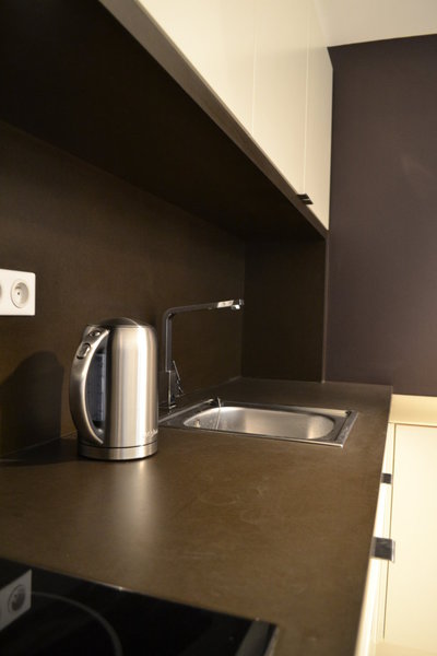 Gros plan sur le PaperStone® un revêtement écologique, à l’aspect minéral et au toucher doux. Sa texture dense et résistante supporte coups et griffures et permet de façonner des plans de travail durables, en cuisine.