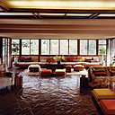 A l’intérieur, le sol minéral dialogue avec les menuiseries en noyer madré, aux fibres irrégulièrement enchevêtrées.