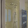 Les deux cabines de douche jumelles de la salle de bains commune sont séparées par un radiateur sèche-serviettes