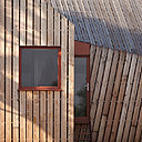 Murs et toitures se prolongent et sont traités dans la même continuité avec un matériau identique, le bardage de bois.