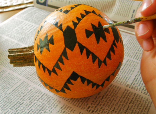 Après avoir tracé légèrement les motifs avec un crayon gras, peignez les motifs avec de la peinture et un pinceau fin.