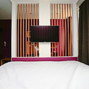 Le claustra en bois sépare, sans le diviser, l’espace et a permis d’intégrer les câbles pour la TV et internet. Cet écran rend l’espace plus intime, tout en profitant du volume de la pièce.