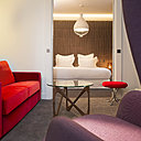 La suite Saint Léger. Tête de lit  en marqueterie de cuir, Studioart. Fauteuil de Jaime Hayon, Fritz Hansen. Canapé sur mesure, Peyroux&Thisy. Table basse, Objekto. Tabouret, Verner Panton, Verpan. Applique de Philippe Nigro, Foscarini. Suspension de Edmondo Testaguzza, Karman. Lampe de chevet de Magnus Pettersen, Italla. Moquette, Balsan.