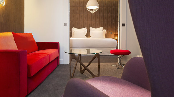 La suite Saint Léger. Tête de lit  en marqueterie de cuir, Studioart. Fauteuil de Jaime Hayon, Fritz Hansen. Canapé sur mesure, Peyroux&Thisy. Table basse, Objekto. Tabouret, Verner Panton, Verpan. Applique de Philippe Nigro, Foscarini. Suspension de Edmondo Testaguzza, Karman. Lampe de chevet de Magnus Pettersen, Italla. Moquette, Balsan.