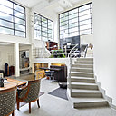 La pièce à vivre est éclairée par la lumière naturelle diffusée par de larges baies vitrées qui donnent sur une terrasse.