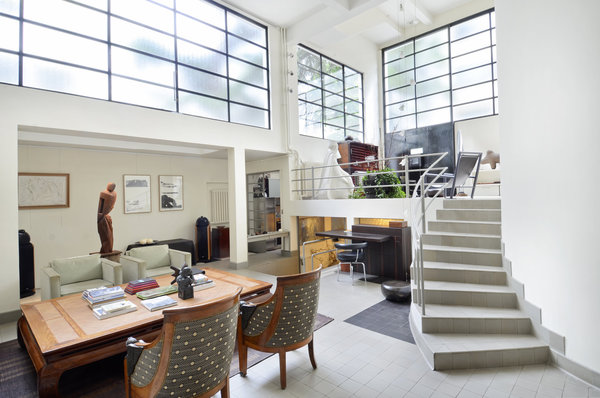 La pièce à vivre est éclairée par la lumière naturelle diffusée par de larges baies vitrées qui donnent sur une terrasse.
