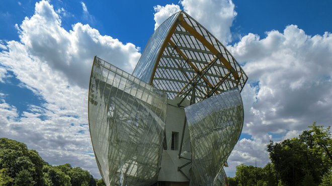 Posé sur un bassin créé avec les fondations, l’édifice s’insère dans l’environnement naturel, entre bois et jardin, jouant de la lumière et des effets de miroir. Fondation Louis Vuitton.