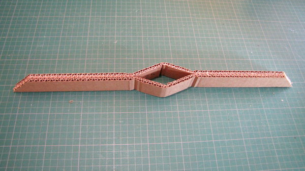 Etape 8 : Pliez les bandes de carton. Collez ensemble les 2 rectangles de carton de même taille, sauf au centre pour permettre le passage du tube carré.