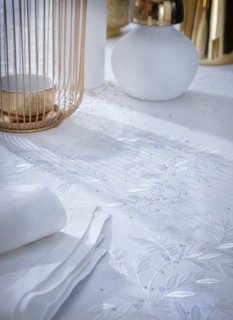 Tout en délicatesse, une nappe brodée de feuillages et plumetis d'étoiles. En lin blanc et lurex argent. Existe en plusieurs dimensions. La nappe, à partir de 270 €. Le tête à tête à partir de 120 €. Pleïades. Alexandre Turpault.