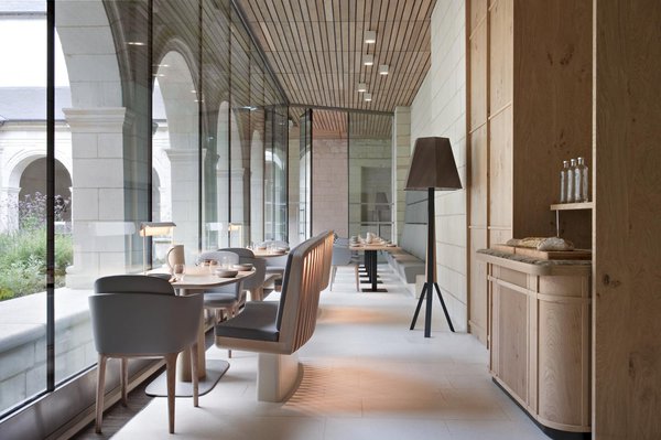 Dans le cloitre, le fauteuil Manda, conçu par l’agence Patrick Jouin iD et édité par la firme italienne Gruppo Industriale Busnelli a été installé dans sa version en cuir avec un piètement en hêtre teinté. La table a été conçue sur mesure et fabriquée par CAA.