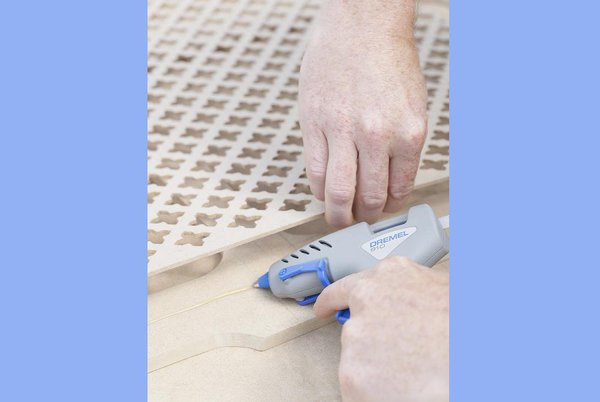 Etape 6 : Maintenant, avec votre pistolet à colle Dremel et un bâton de colle transparente de 7 mm, collez la grille à motif sur l’envers de la face principale du panneau MDF.