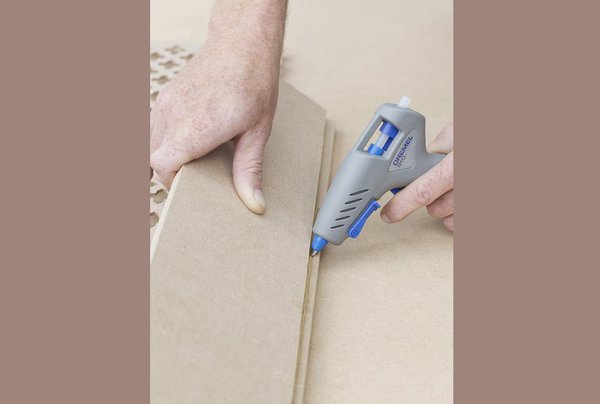 Etape 7 : Ensuite, avec votre pistolet à colle Dremel et un bâton de colle transparente, assemblez et collez toutes les sections, puis vissez la face principale aux panneaux latéraux et vissez enfin le panneau de dessus sur le coffrage que vous avez réalisé. Placez l’ensemble par-dessus la plinthe et les tuyaux afin de l’appliquer contre le mur. Avec du mastic pour bois, couvrez les trous de vis. Appliquez ensuite une sous-couche, peignez et, pour finir, fixez l’ensemble au mur avec des supports internes.