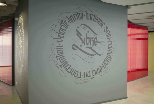 La calligraphie guide le visiteur dans les différents espaces différenciés par des matériaux différents : rideau translucide pour les espaces d’attente, carrelage pour les lieux humides, bois pour les zones d’entrainement…