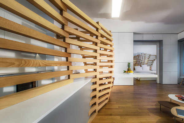 Composée de 131 pièces de bois, le claustra, telle une colonne vertébrale, a été dessiné par ordinateur et trace un volume en courbe, des lignes organiques et un effet de dilatation.