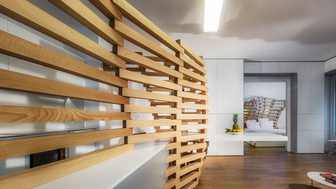 Composée de 131 pièces de bois, le claustra, telle une colonne vertébrale, a été dessiné par ordinateur et trace un volume en courbe, des lignes organiques et un effet de dilatation.