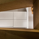 Les façades des rangements sont personnalisées par un jeu de diagonales qui jouent avec le treillis du claustra.