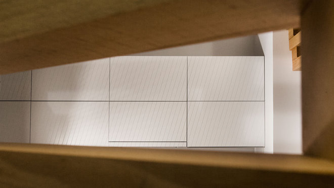 Les façades des rangements sont personnalisées par un jeu de diagonales qui jouent avec le treillis du claustra.