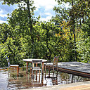 Un bassin d’eaux de pluie prolonge naturellement la terrasse vers la forêt environnante.