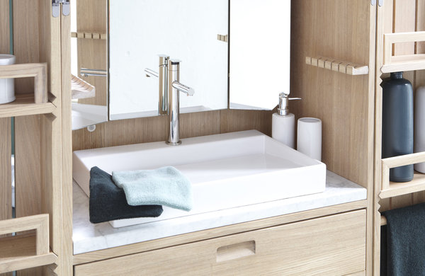 La vasque en céramique repose sur un plateau en marbre de Carrare. Les miroirs avec panneaux latéraux sont orientables.