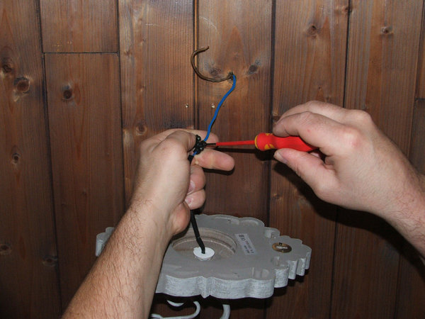 Etape 1 : Reliez le fil de neutre. Vérifiez si le fil est bien dénudé, sur l’emplacement du domino du luminaire en le vissant.