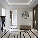 Dans l’entrée, le motif graphique au sol fait écho à l’architecture particulière de la Tour Eiffel. Vase, Galerie Touperat et porte-vase Pierre Medioni. Sol bicolore, Marbrerie de la Seine (Galaxy Bronze Marble and Beige Thala). Miroir, Rosy by Doriana & Massimiliano Fuksas for FIAM. Panneau en cuir patiné façon mica, Christophe Fey.