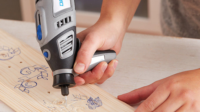 Étape 6 : Tracez le motif floral à l'aide de la Dremel 8100 et d'une fraise à graver 106. La poignée de précision vous assure une gravure précise. Passez une couche de finition sur la planche, par exemple, de vernis. Vissez les cintres découpés dans les trous de la planche. Votre œuvre est terminée.