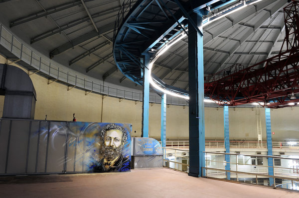 Grande figure qui a inspiré des vocations, Jules Verne, écrivain fleuve de romans d’aventure et de  science-fiction durant la deuxième moitié du 19ème siècle. Ses « Voyages extraordinaires », 62 romans et 18 nouvelles, ont paru pour beaucoup aux Editions Hetzel. La célèbre typographie des couvertures de ces éditions a été reprise par C215 pour titrer sa peinture. Cette œuvre de C215, la plus grande de toutes à Saclay, a été positionnée en haut de l’ancien réacteur à eau lourde n°3. Un réacteur conçu avec l’aide de sous-mariniers, clin d’œil à « 20 000 lieues sous les mers »…