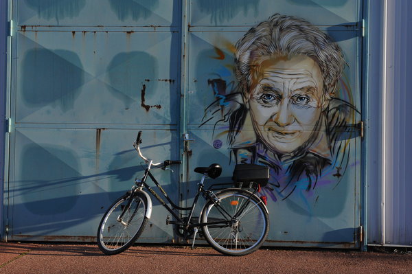 Georges Charpak, physicien français, a reçu le prix Nobel en 1992. Spécialiste de la détection des particules, il a inventé les « chambre à fils » utilisées au Cern, à Genève. Le Cern, laboratoire tunnel circulaire de 27 km sous la frontière franco-suisse, est le plus grand et le plus puissant accélérateur du monde pour la physique des particules. C’est là qu’a été découvert le boson de Higgs en 2012. Georges Charpak travaillait avec le CEA, il est peint sur un bâtiment où il venait travailler.