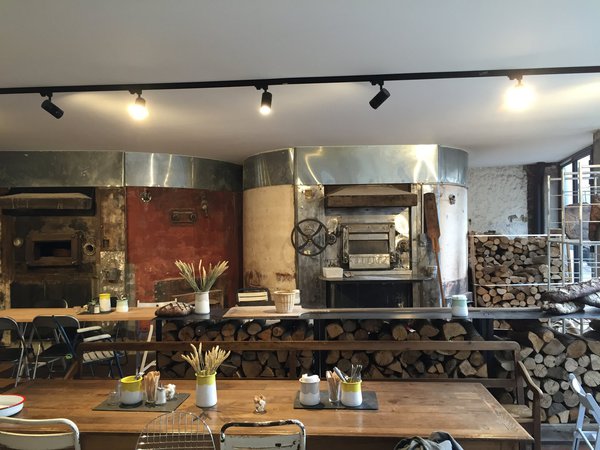 L'une des grandes tables et les buches prêtes à être enfournées.