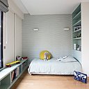 Dans la chambre de l’autre garçon, ambiance pastel avec une peinture bleu ciel qui met en valeur le décor géométrique du papier-peint.