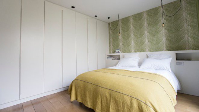 Un grand linéaire de placards occupe toute la longueur de la pièce. Ses portes laquées en blanc avec prise de main discrète s’intègrent dans l’espace.