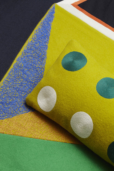 Pour réaliser cette broderie sur fond jaune, il a fallu réinventer, grâce à la vieille machine Cornely datant du XIX° siècle, un point évoquant un crayon de couleur.  Coussin cale-dos collection pois en drap de laine brodé, Edition Le Déan-Prieur, réalisé par Le Minor, Pont l’Abbé, 70 x 26 cm 215 euros.