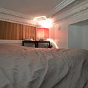 Le lit pour deux personnes est coiffé par les anciennes corniches et moulures conservées et restaurées du plafond.