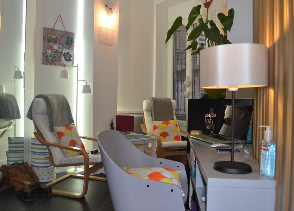 Le salon trop étroit pour recevoir un vrai canapé est meublé avec des fauteuils. Un bureau a été installé contre la cloison arrondie tapissée d’un papier-peint imitant les plis d’un rideau. Le sol est recouvert de grandes dalles de grès cérame qui agrandissent l’espace.