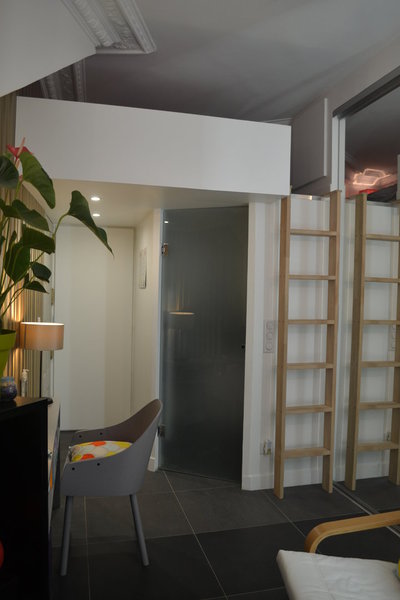 Dès l’entrée, l’espace a été travaillé pour intégrer les rangements. La porte ouverte cache, en partie basse, la machine à laver mais, en partie haute, des étagères.