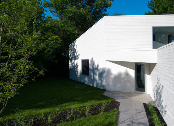 L’entrée se fait discrète et se fond dans la masse des volumes tout blancs.