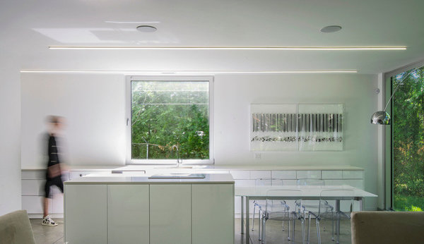 La cuisine s’étend sur toute la longueur, avec un îlot central prolongé par un coin repas. Tout en légèreté, elle bénéficie de la vue sur le jardin.