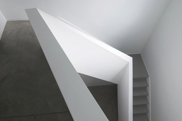 L’escalier en béton laisse courir ses lignes anguleuses formant une spirale.