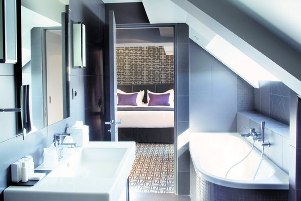 Salles de bains contemporaines et recouvertes de grandes dalles de grès cérame gris.