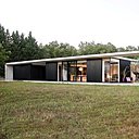 Côté sud, la façade offre une longueur de 42 mètres. Le volume parallélipédique de la maison joue la carte de la forme géométrique pure. Les pièces sont baignées de lumière et favorisent les apports solaires en hiver.