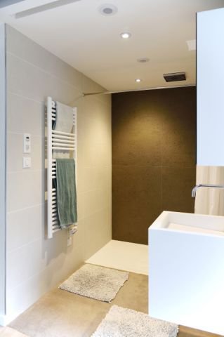 La salle de bains des parents met en évidence une douche ouverte à l’italienne avec receveur extraplat, à fleur de sol.