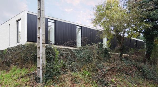 Côté nord, les fenêtres étroites contrastent avec les larges baies vitrées de la façade sud.