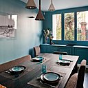 La salle à manger a été mise en valeur par une peinture bleu turquoise qui fait écho aux canapés du salon.