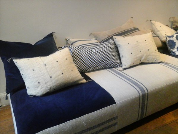 Elégance d'un divan recouvert de lin et velours bleu en parfaite harmonie avec les coussins.