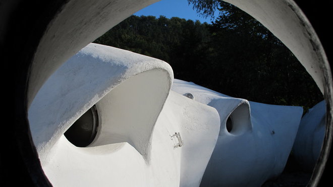 Des fenêtres rondes qui découpent des vues sur le jardin et la végétation extérieure. Des fenêtres rondes qui découpent des vues sur le jardin et la végétation extérieure.