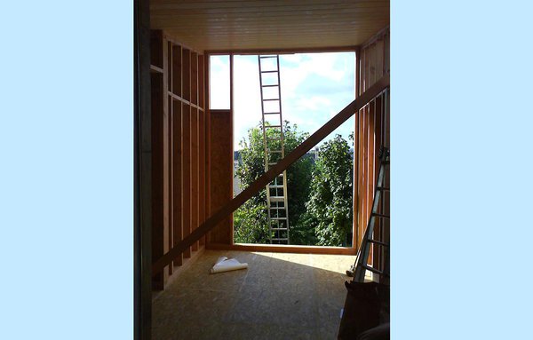 Construction d’une extension à ossature bois en sapin Douglas traité. La surface surélevée avec vue sur les arbres du jardin offre une pièce en plus, un salon précisément, pour un petit budget. Réalisation Didier Foulon pour Anagram Atelier d’Architecture.