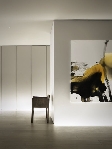 Dans le couloir, qui offre un effet de galerie pour circuler dans tout l’appartement, une peinture de lotus par Cheng Jiang Hong.