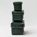 Boîtes gigogne en cuir noir avec bordures cousues de points de croix.